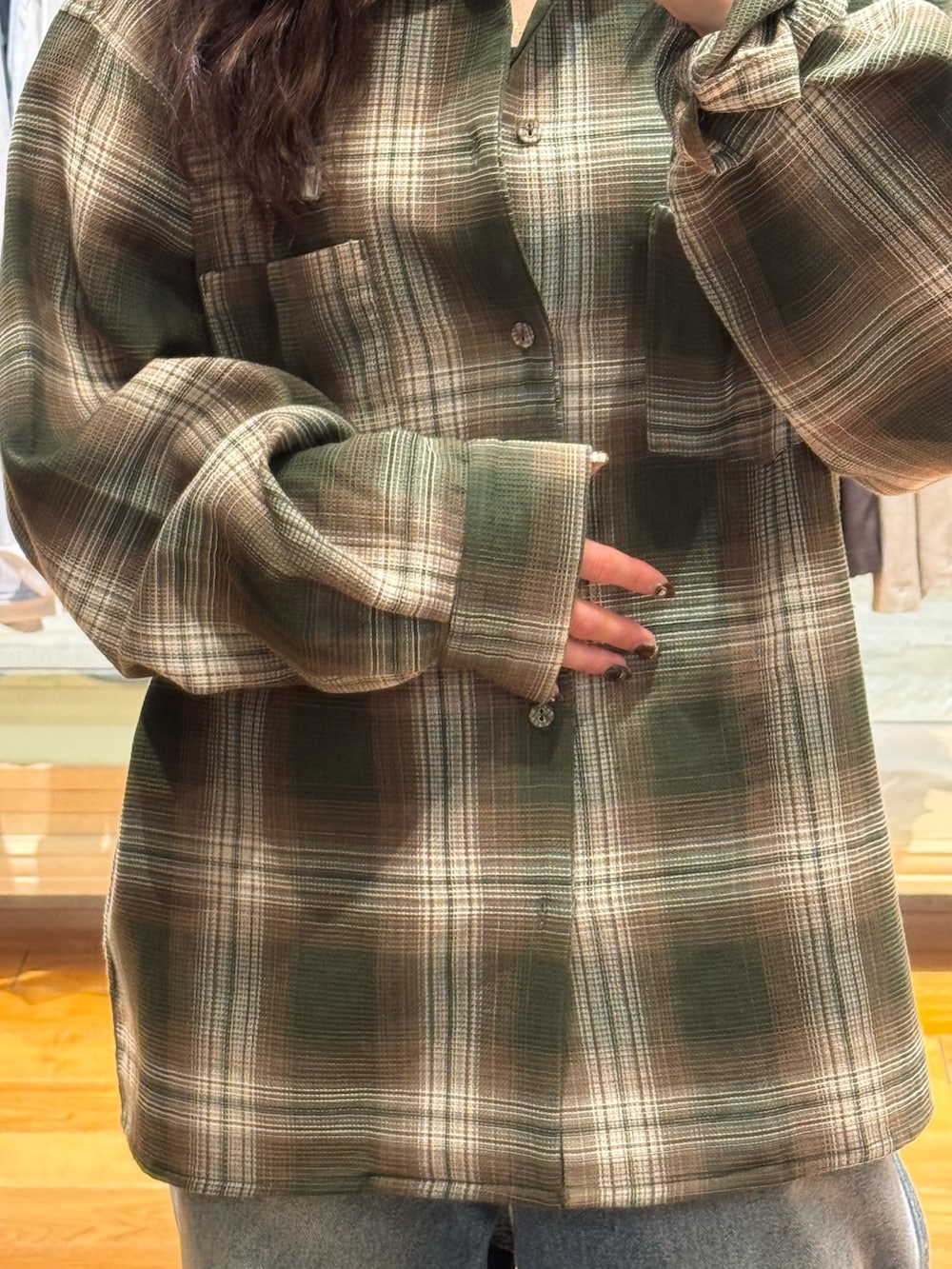 グリーン系のシャツ/ブラウス、ブルー系のデニムパンツを着用したレディースの秋コーディネートの3枚目の写真