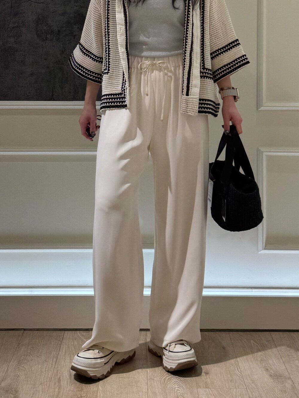 ブラック系のトートバッグ、シルバー系のTシャツ/カットソー、ホワイト系のシャツ/ブラウスを着用したレディースの春コーディネートの4枚目の写真