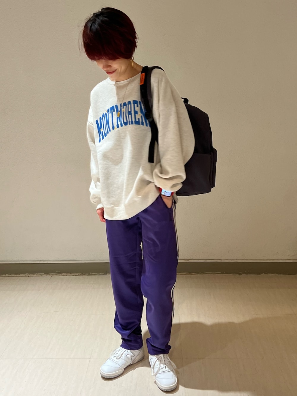 グレー系のスウェット、パープル系のその他パンツ、ホワイト系のスニーカーを着用したレディースの冬コーディネートの2枚目の写真