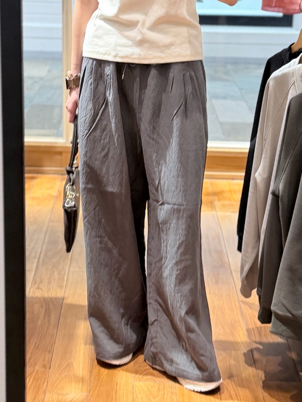 グレー系のその他パンツ、ブラウン系のショルダーバッグ、ホワイト系のTシャツ/カットソーを着用したレディースの春コーディネートの4枚目の写真