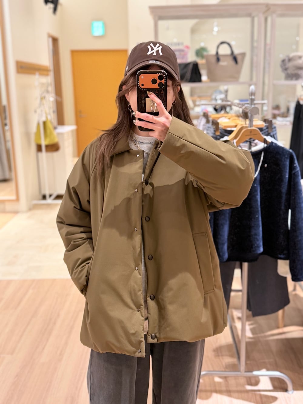 グリーン系のダッフルコート、ベージュ系のスウェットパンツ、ホワイト系のスウェットを着用したレディースの冬コーディネートの2枚目の写真