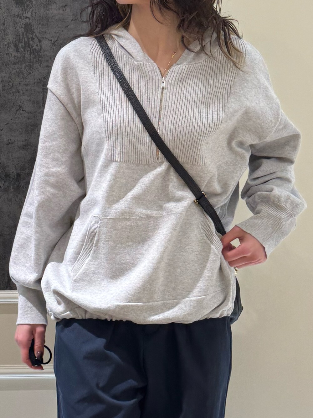 グレー系のニット/セーター、ブラック系のショルダーバッグ、ブルー系のその他パンツを着用したレディースの春コーディネートの2枚目の写真