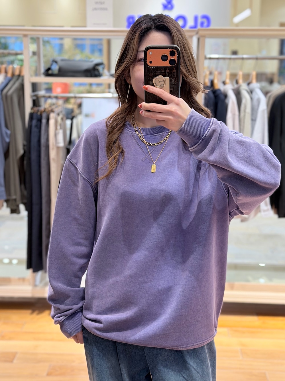 パープル系のスウェット、ブルー系のデニムパンツを着用したレディースの春コーディネートの2枚目の写真