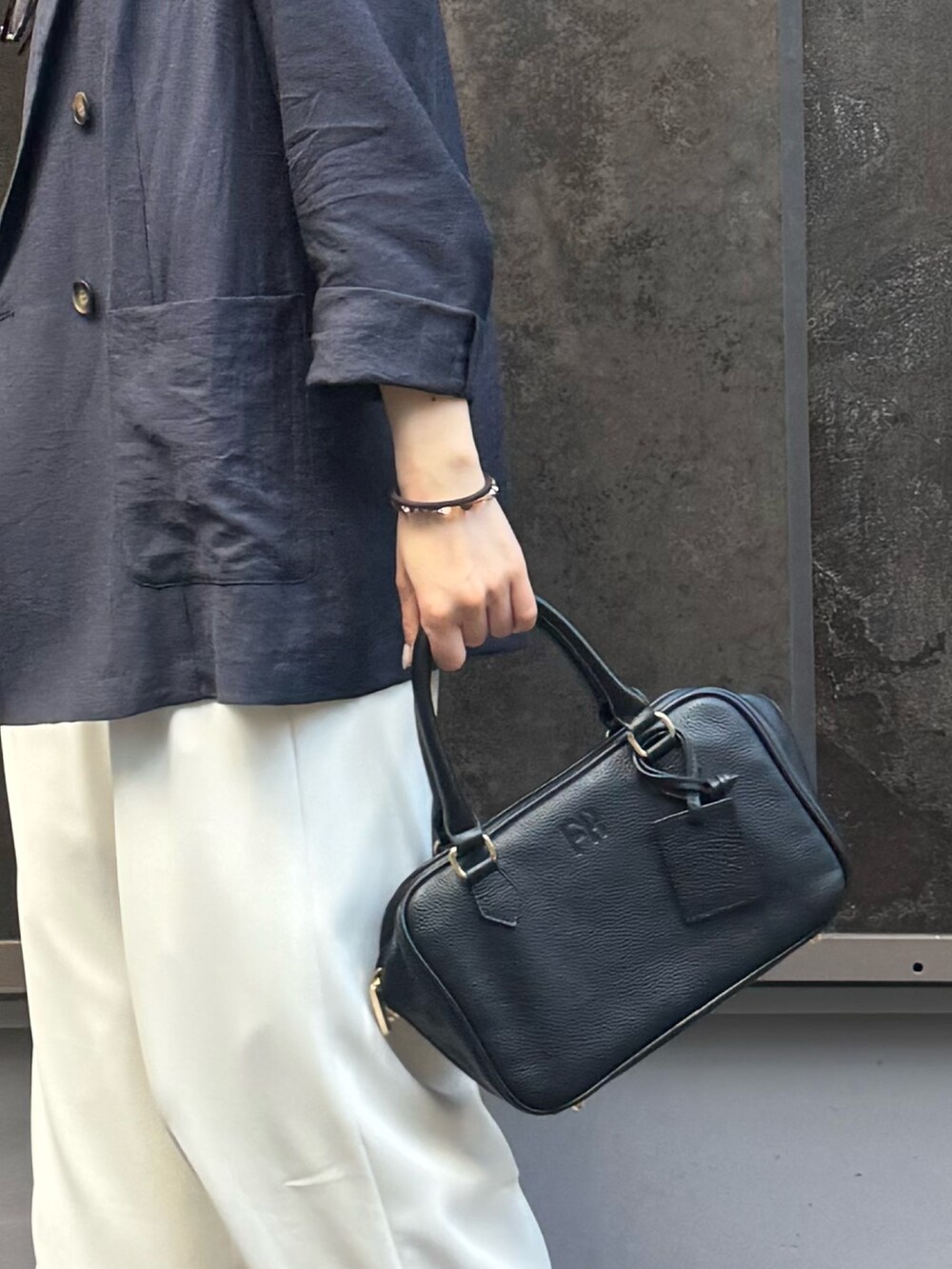 イエロー系のショルダーバッグ、ベージュ系のテーラードジャケット、ベージュ系のその他パンツを着用したレディースの春コーディネートの6枚目の写真