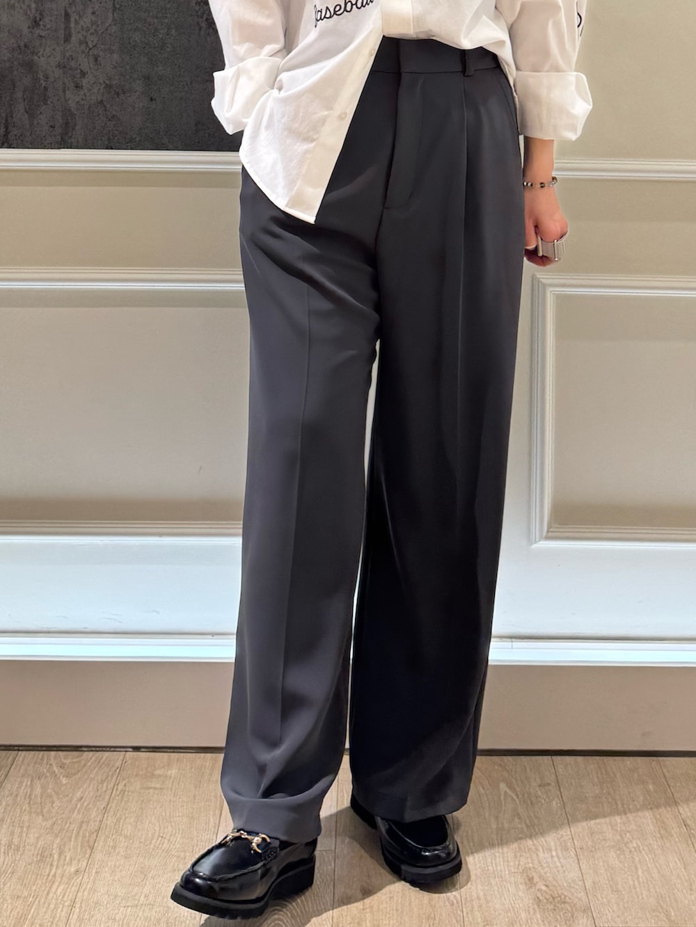 ホワイト系のシャツ/ブラウス、グレー系のスラックス、ブラック系のショルダーバッグを着用したレディースの春コーディネートの5枚目の写真