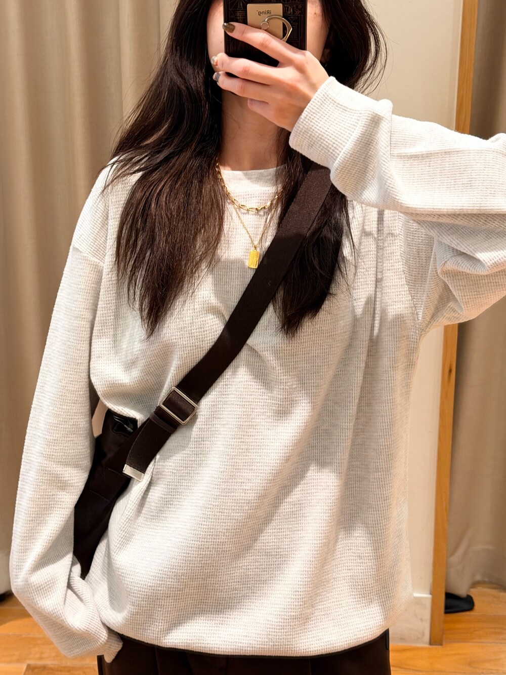 グレー系のTシャツ/カットソー、ブラウン系のショルダーバッグ、ブラウン系のスラックスを着用したレディースの秋コーディネートの4枚目の写真