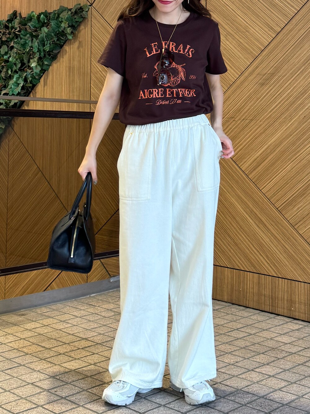 ブラウン系のTシャツ/カットソー、ホワイト系のデニムパンツ、ブラック系のショルダーバッグを着用したレディースの夏コーディネートの5枚目の写真