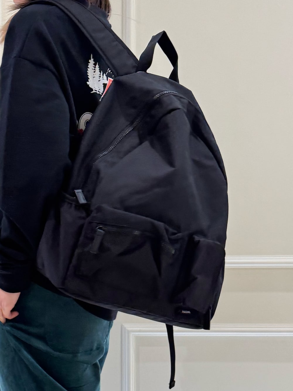 ブラック系のスウェット、グリーン系のその他パンツ、ブラック系のバックパック/リュックを着用したレディースの冬コーディネートの2枚目の写真