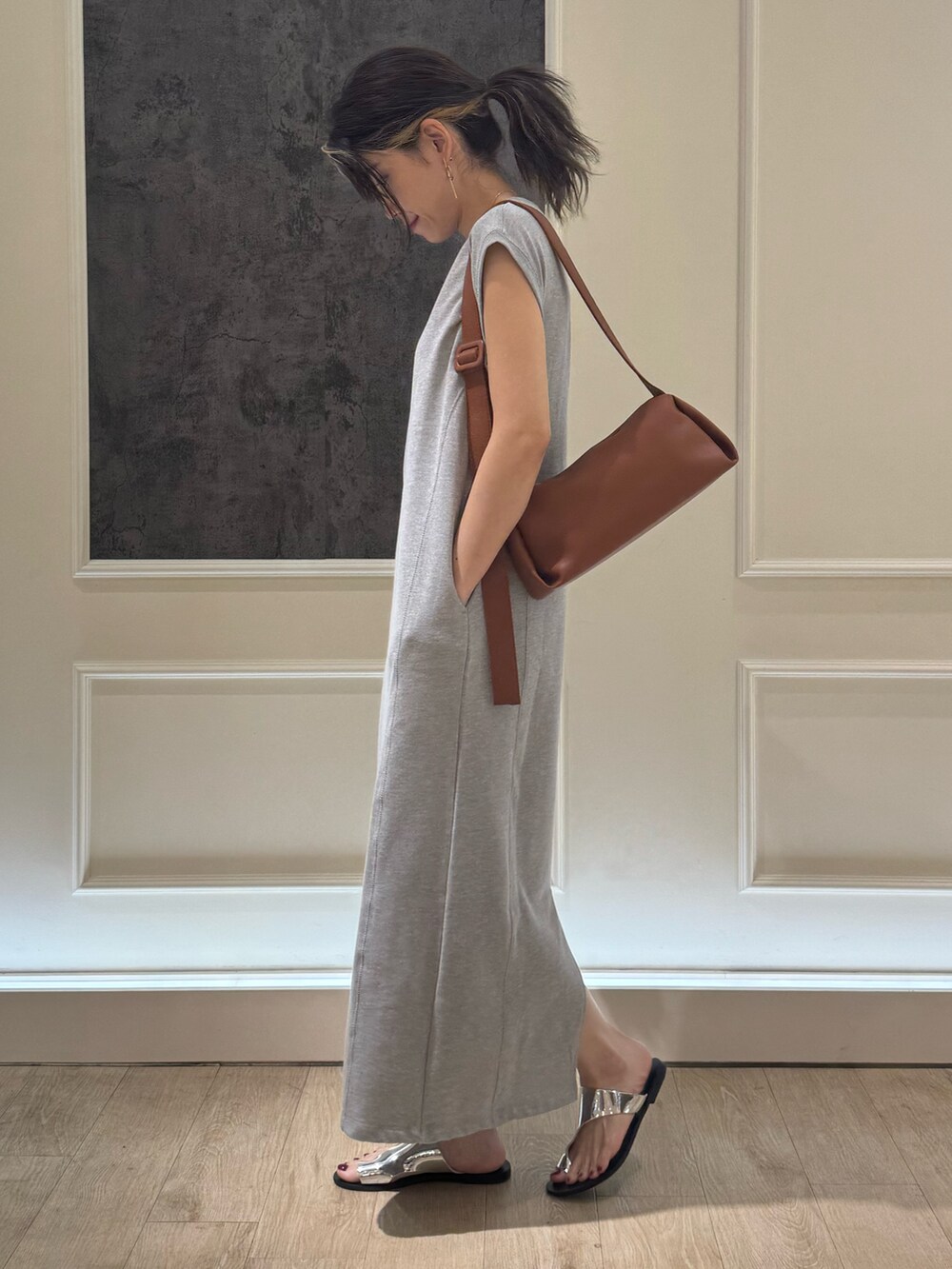 グレー系のワンピース、イエロー系のショルダーバッグ、シルバー系のサンダルを着用したレディースの夏コーディネートの3枚目の写真