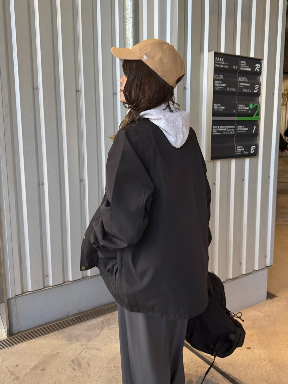 ブラック系のブルゾン、グレー系のその他パンツ、ブラック系のバックパック/リュックを着用したレディースの冬コーディネートの2枚目の写真