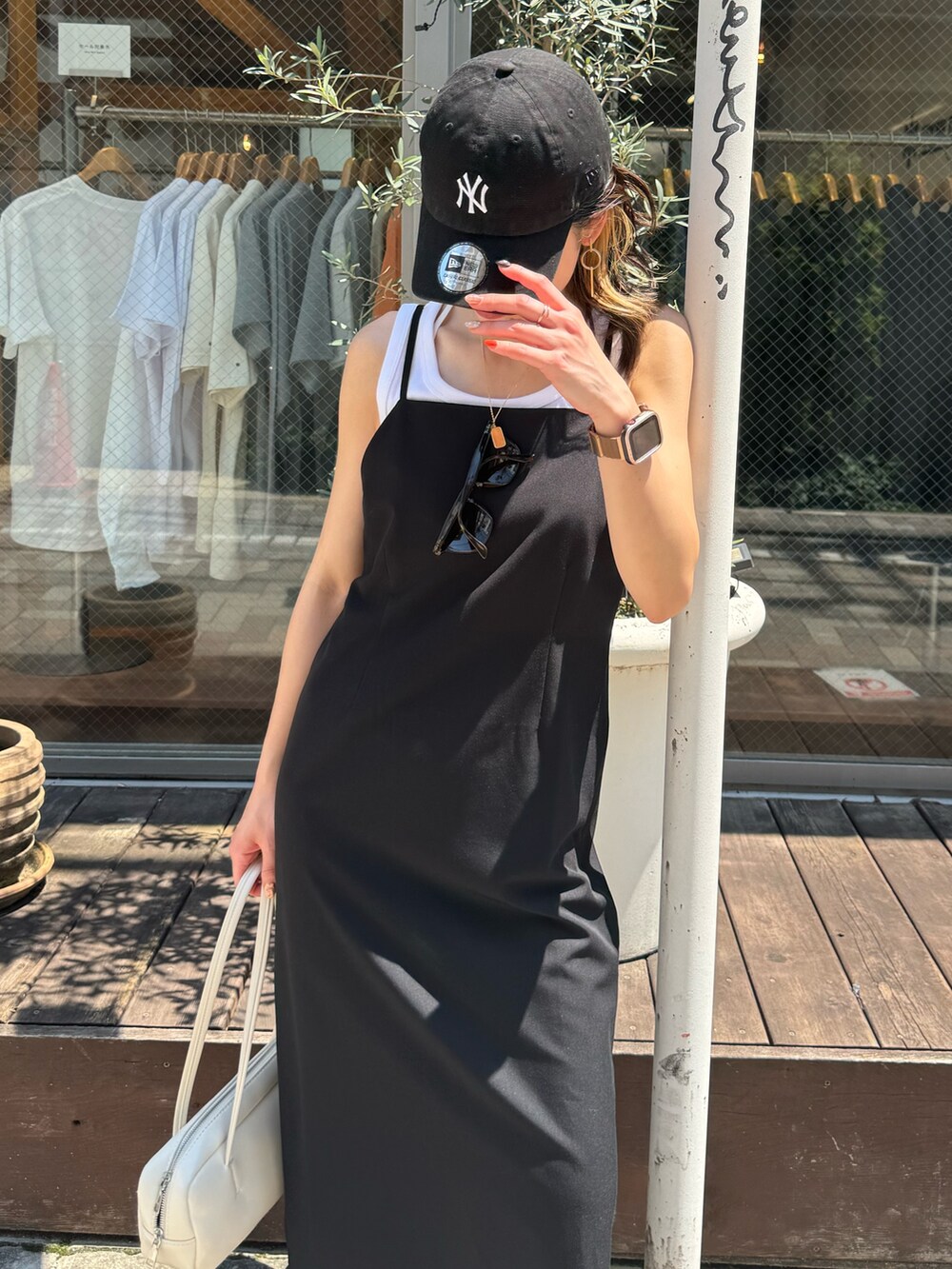 ブラック系のワンピース、ホワイト系のボストンバッグ、シルバー系のサンダルを着用したレディースの夏コーディネートの4枚目の写真