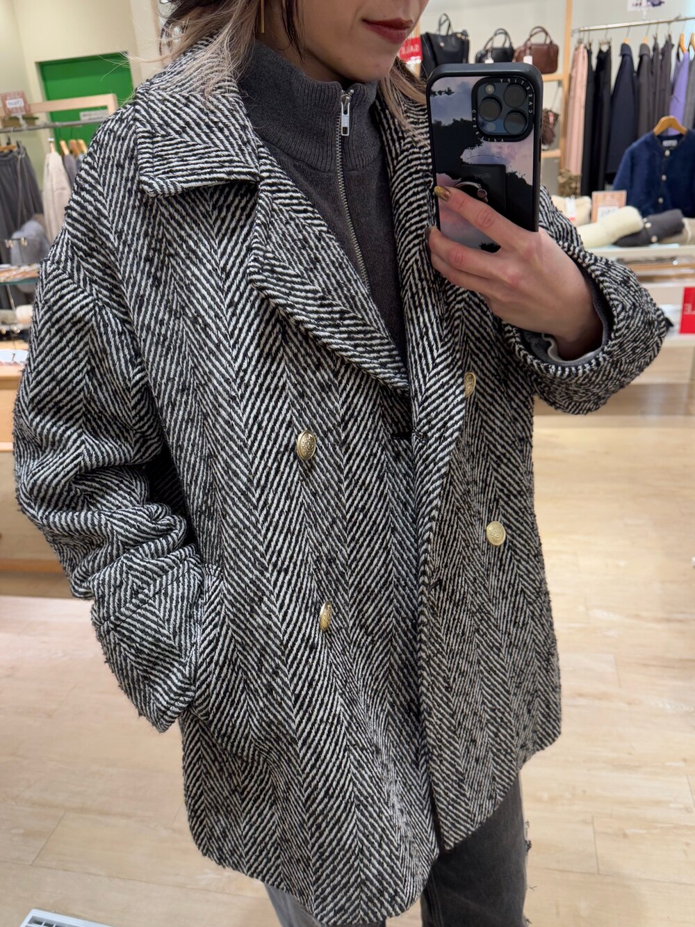 ブラック系のピーコート、グリーン系のニットキャップ/ビーニーを着用したレディースの冬コーディネートの2枚目の写真