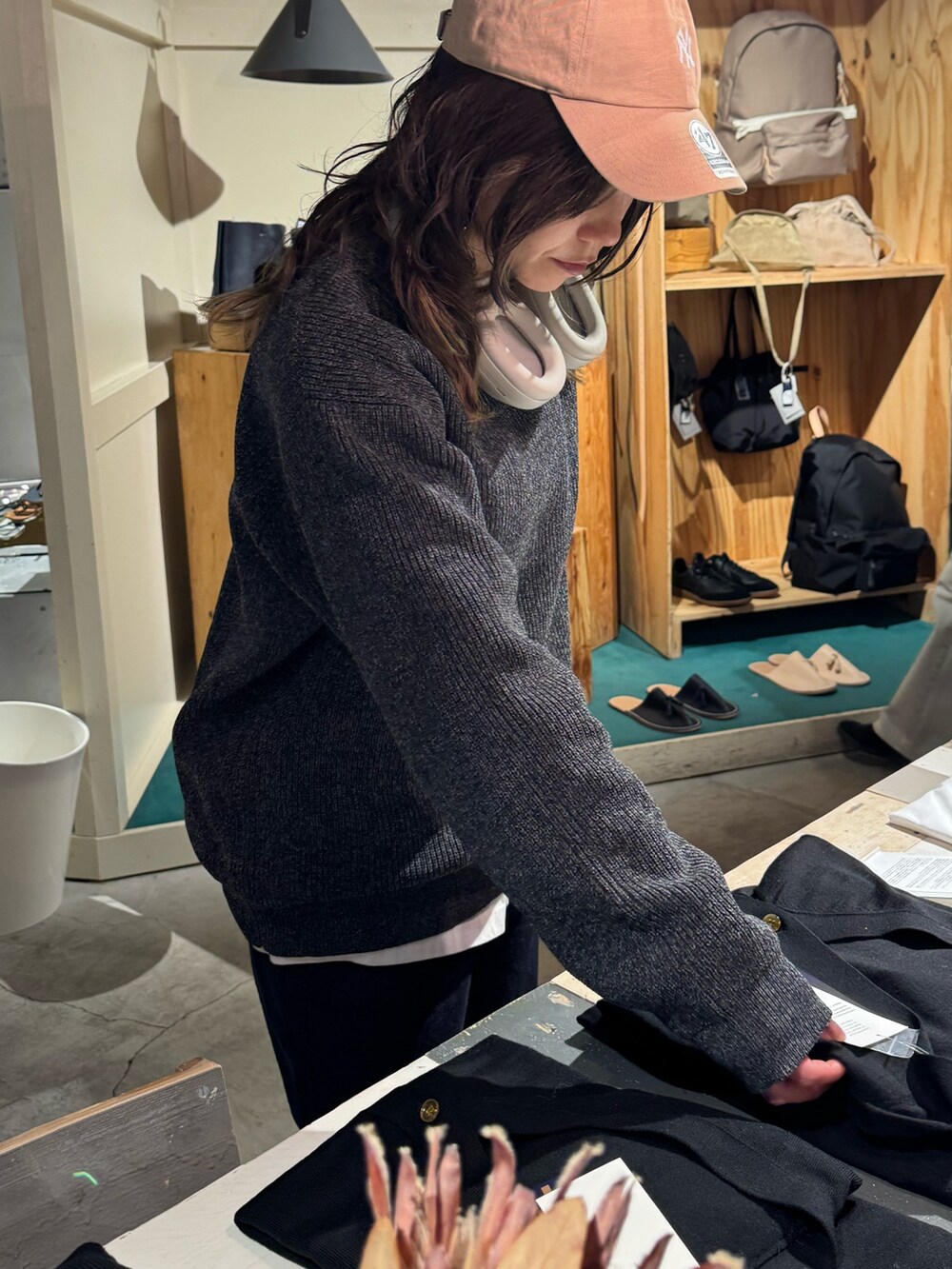 グレー系のニット/セーター、ブルー系のデニムパンツを着用したレディースの冬コーディネートの2枚目の写真