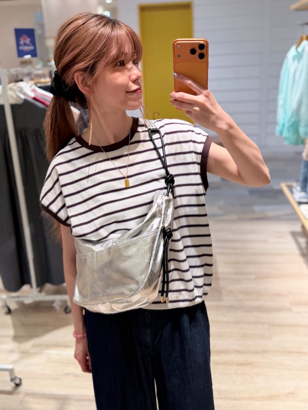 ホワイト系のTシャツ/カットソー、ブルー系のデニムパンツ、ブラック系のショルダーバッグを着用したレディースの夏コーディネートの3枚目の写真