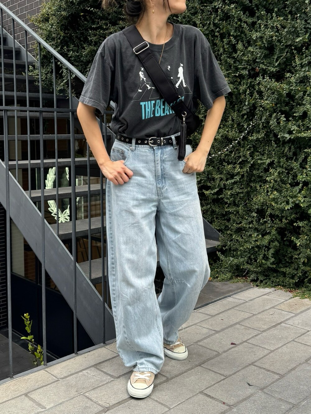 グレー系のTシャツ/カットソー、ブルー系のデニムパンツ、ブラック系のショルダーバッグを着用したレディースの夏コーディネートの2枚目の写真