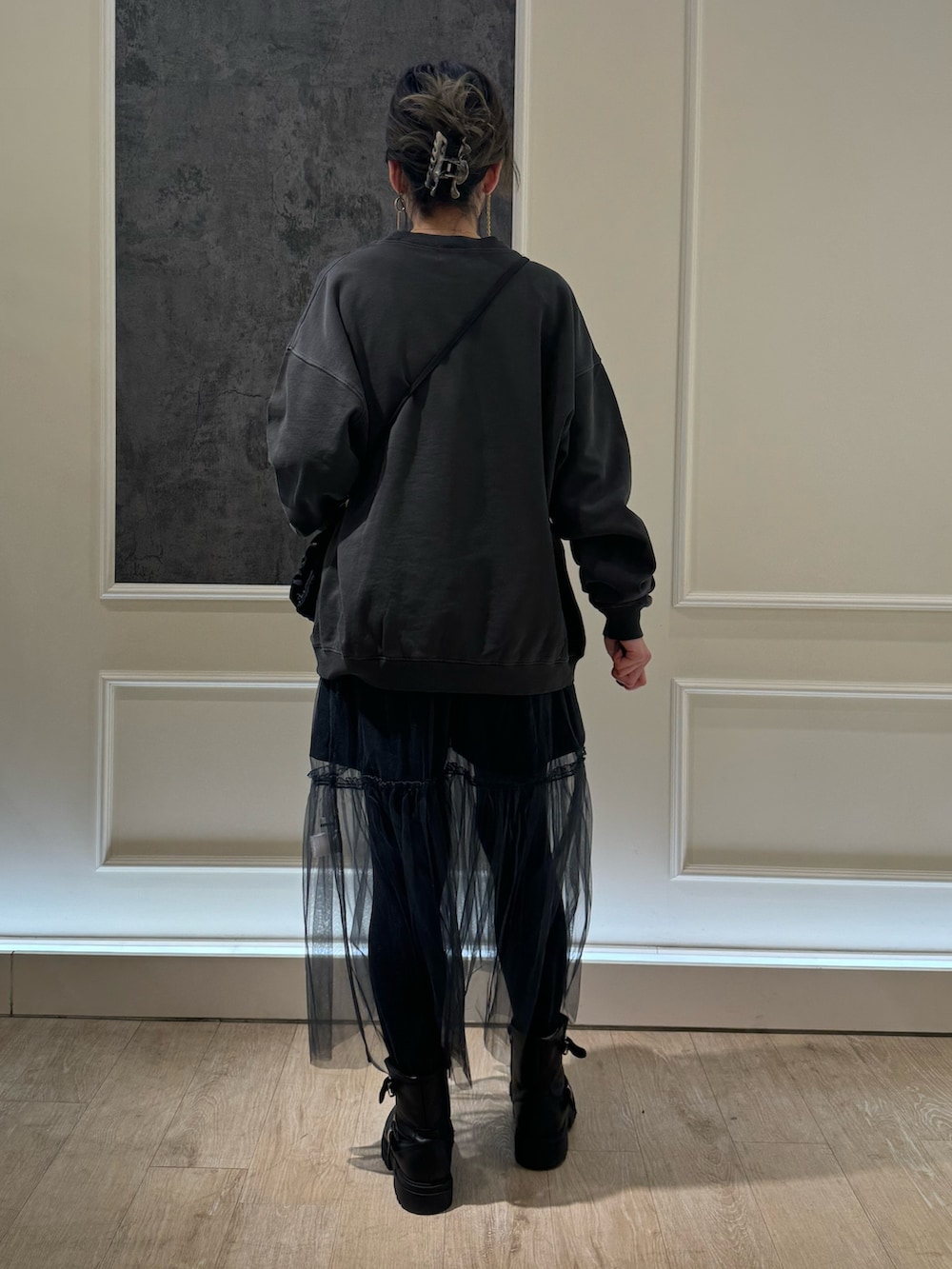 ブラック系のスウェット、グレー系のスカート、ブラック系のブーツを着用したレディースの冬コーディネートの3枚目の写真