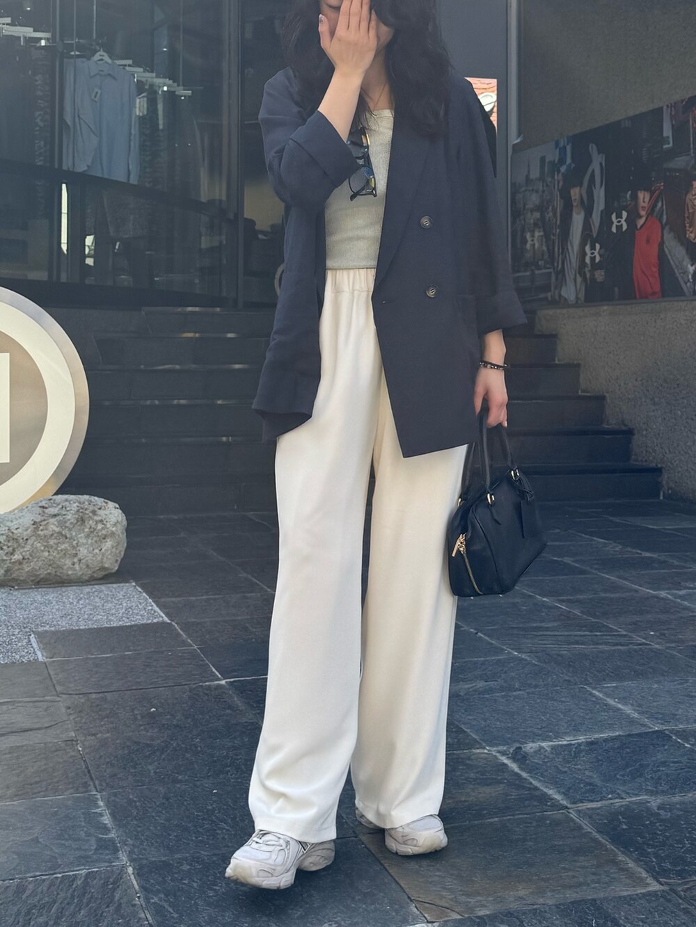 イエロー系のショルダーバッグ、ベージュ系のテーラードジャケット、ベージュ系のその他パンツを着用したレディースの春コーディネートの3枚目の写真