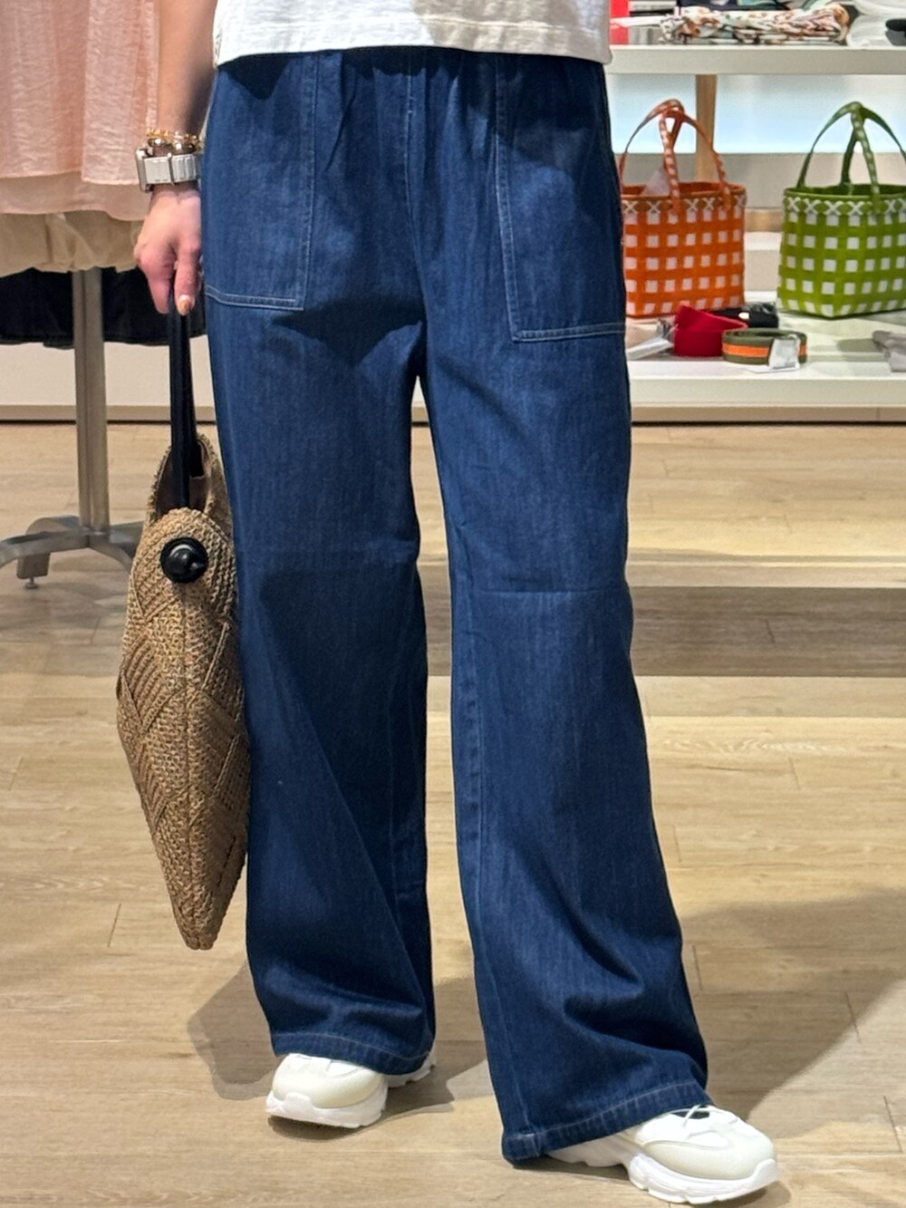 グレー系のTシャツ/カットソー、ブルー系のデニムパンツ、ベージュ系のかごバッグを着用したレディースの夏コーディネートの5枚目の写真