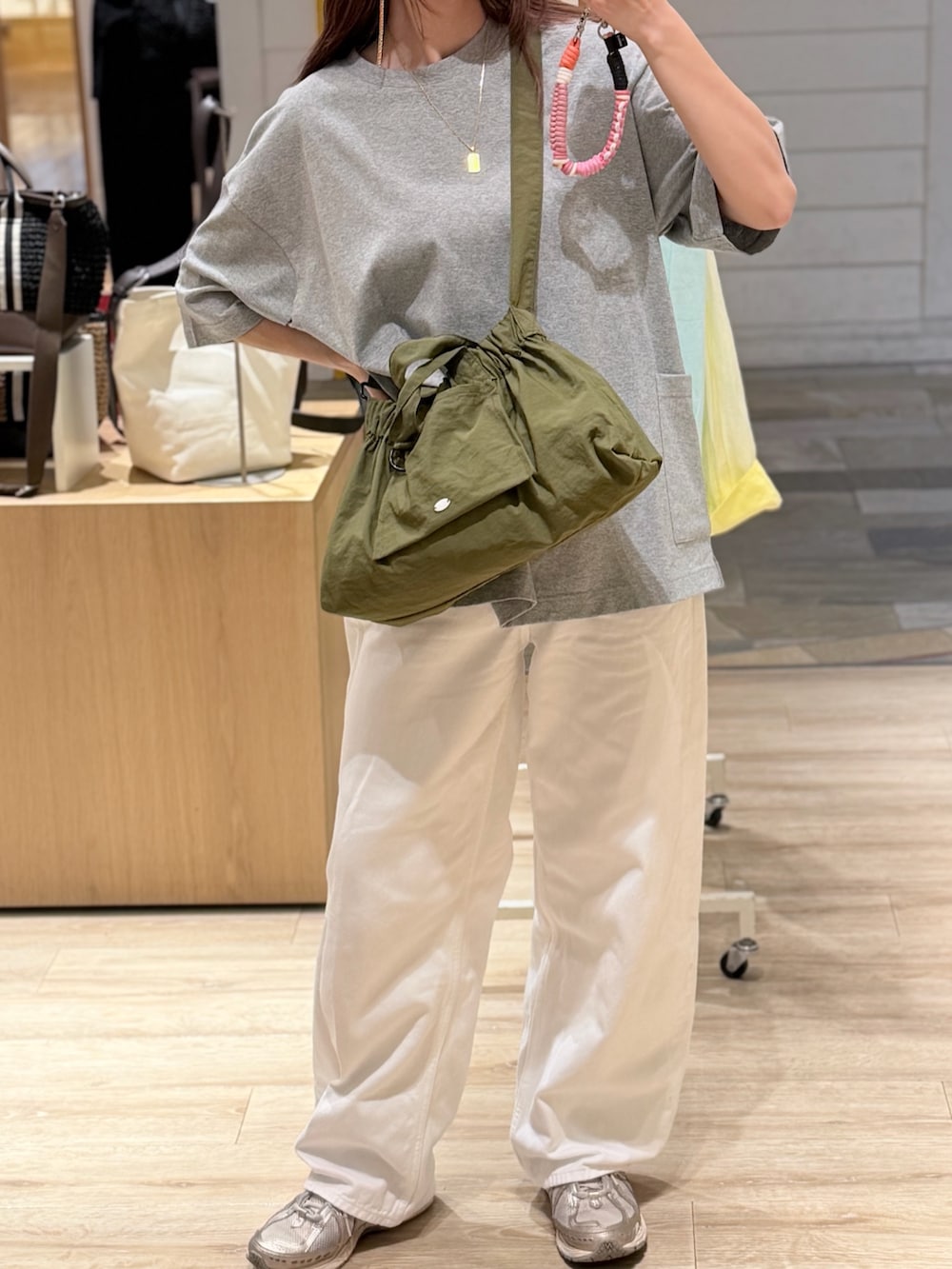 グレー系のTシャツ/カットソー、グリーン系のショルダーバッグを着用したレディースの夏コーディネートの3枚目の写真