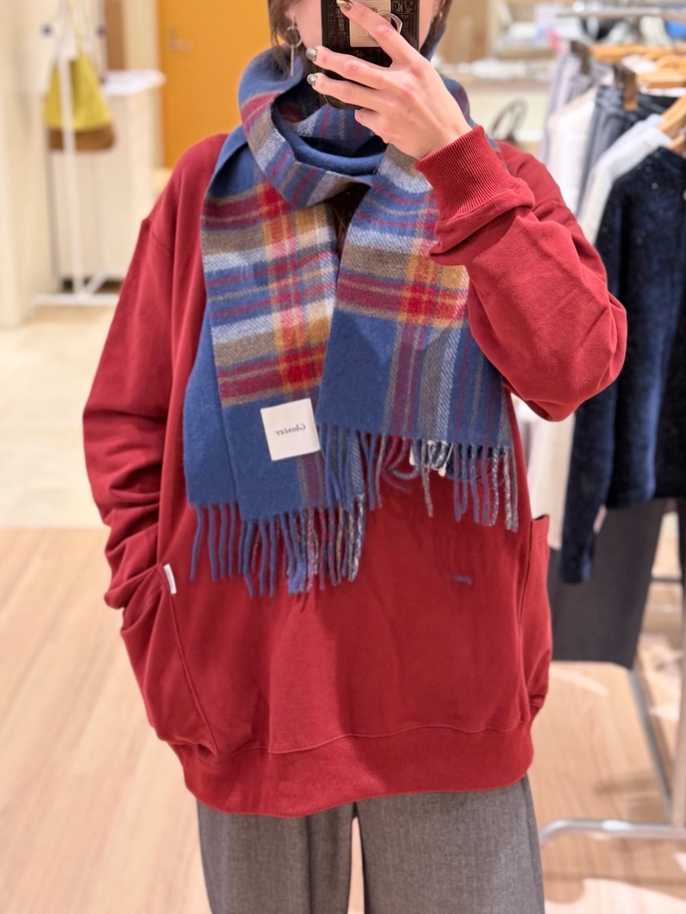 グレー系のその他パンツ、レッド系のスウェット、グリーン系のマフラーを着用したレディースの冬コーディネートの2枚目の写真