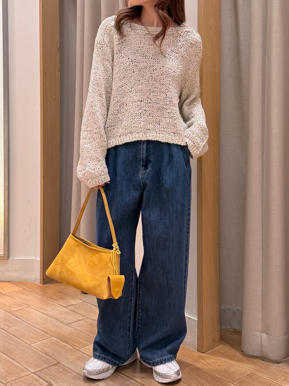 ピンク系のニット/セーター、ブルー系のデニムパンツ、イエロー系のショルダーバッグを着用したレディースの春コーディネートの2枚目の写真