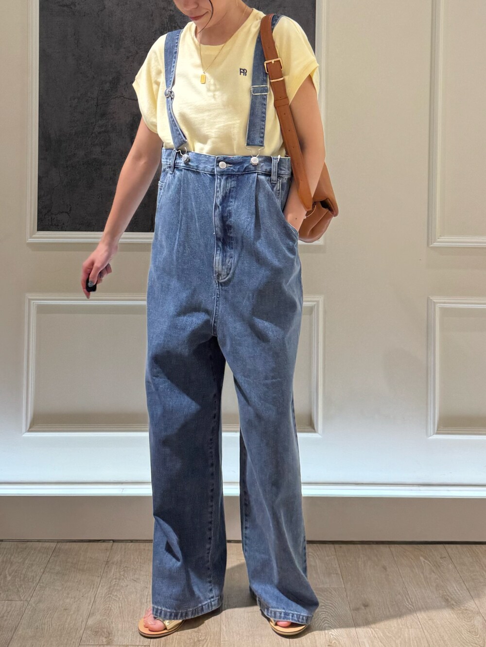 ベージュ系のTシャツ/カットソー、シルバー系のサンダル、ブルー系のデニムパンツを着用したレディースの夏コーディネートの4枚目の写真