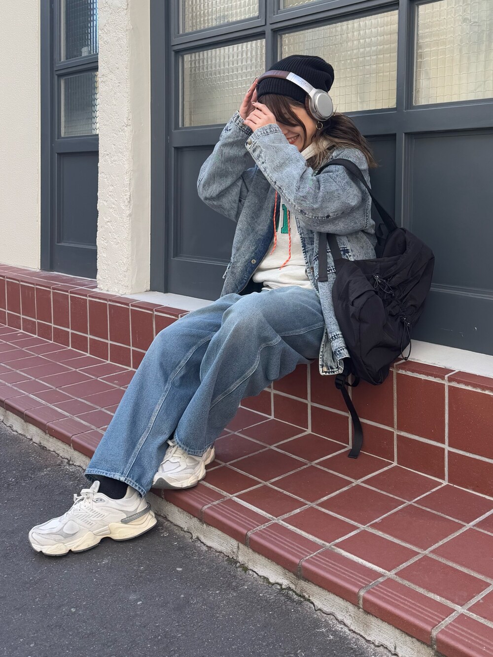 ブルー系のブルゾン、グレー系のスウェット、ブルー系のデニムパンツを着用したレディースの冬コーディネートの3枚目の写真