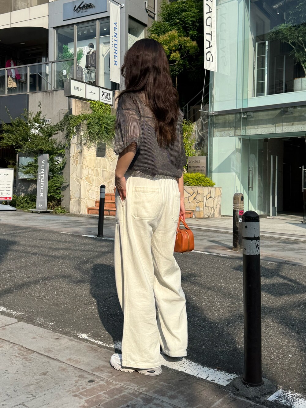 グレー系のTシャツ/カットソー、ブルー系のデニムパンツ、イエロー系のショルダーバッグを着用したレディースの夏コーディネートの5枚目の写真