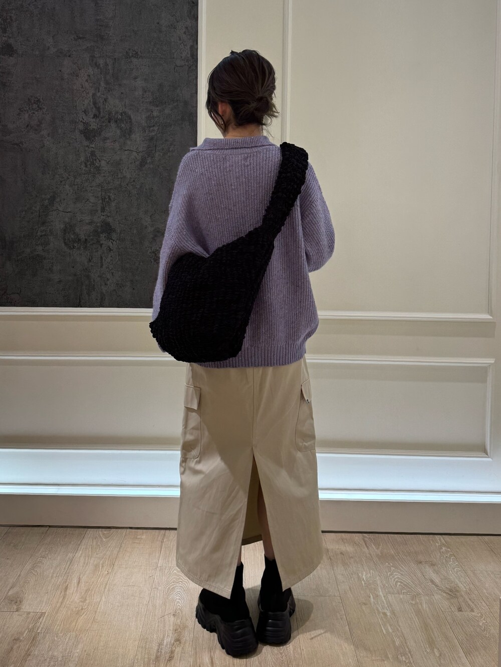 パープル系のニット/セーター、ホワイト系のスカートを着用したレディースの冬コーディネートの3枚目の写真