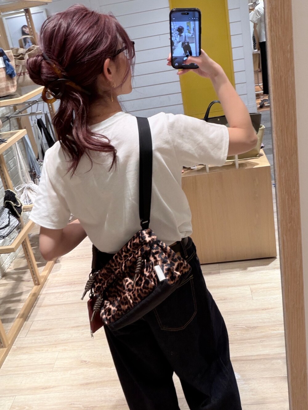 ブラウン系のショルダーバッグ、ホワイト系のTシャツ/カットソー、ブルー系のデニムパンツを着用したレディースの夏コーディネートの4枚目の写真