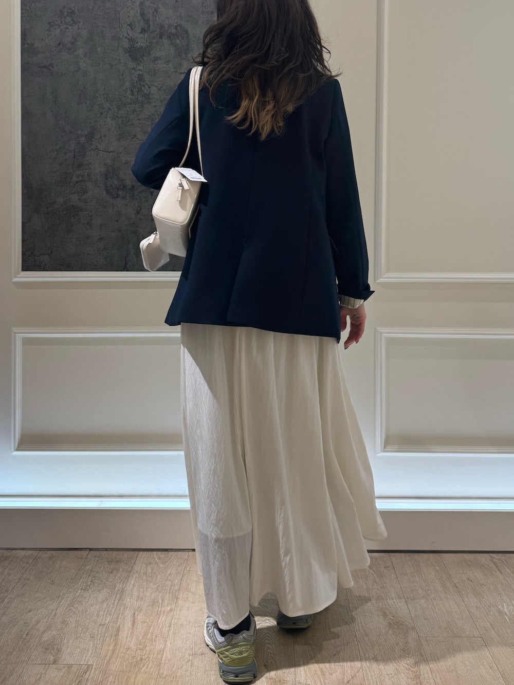 ブルー系のテーラードジャケット、グレー系のTシャツ/カットソー、ホワイト系のスカートを着用したレディースの春コーディネートの3枚目の写真