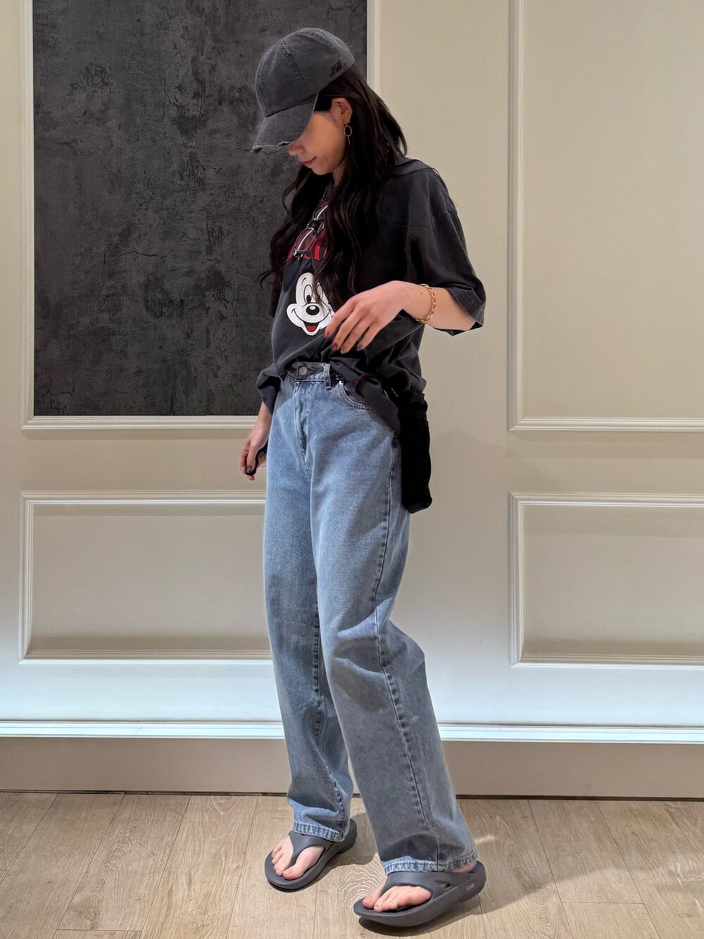 ブラック系のTシャツ/カットソー、ブラック系のデニムパンツ、グレー系のサンダルを着用したレディースの春コーディネートの2枚目の写真