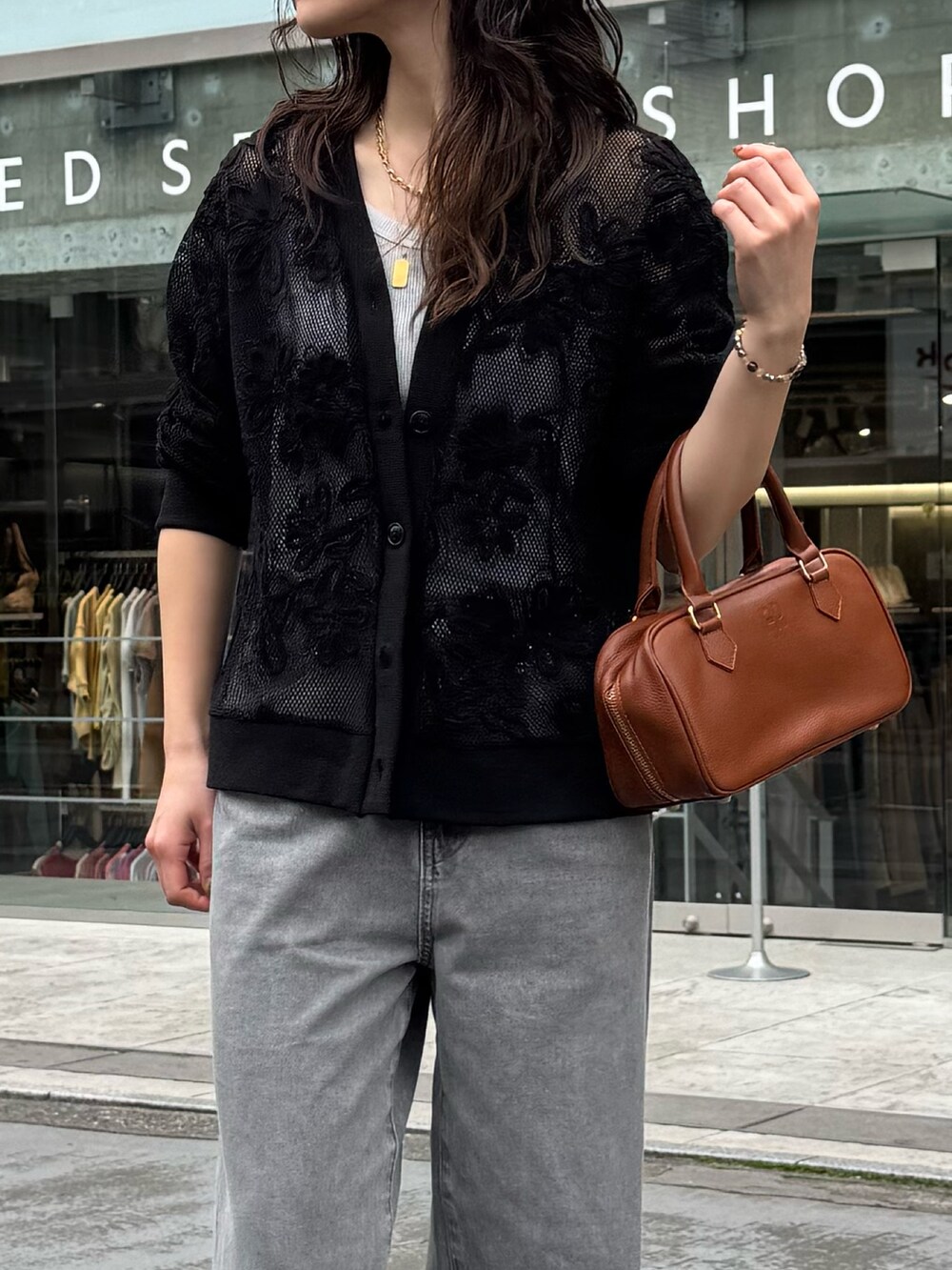 ブラック系のカーディガン/ボレロ、ベージュ系のデニムパンツを着用したレディースの春コーディネートの4枚目の写真