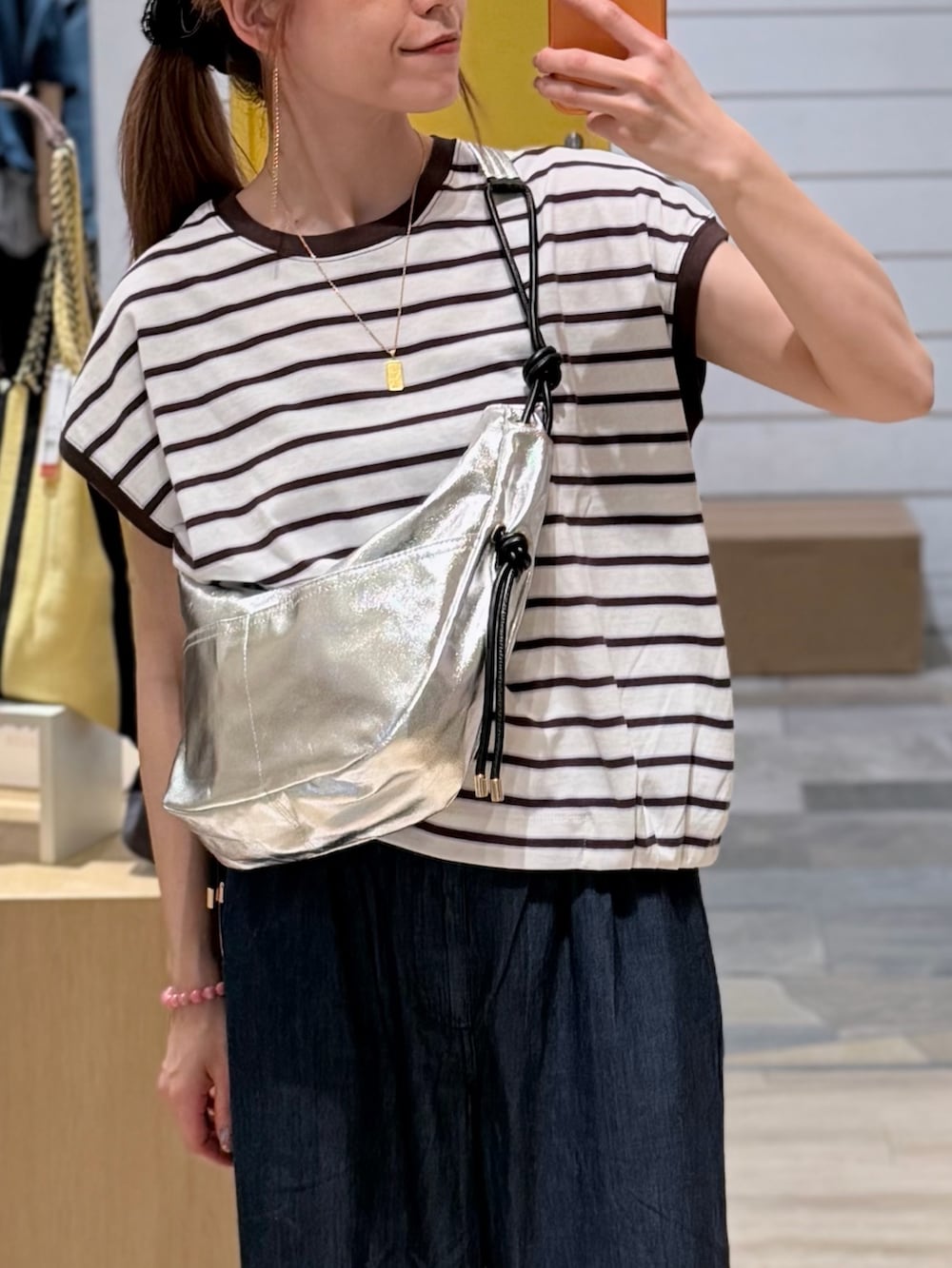 ホワイト系のTシャツ/カットソー、ブルー系のデニムパンツ、ブラック系のショルダーバッグを着用したレディースの夏コーディネートの2枚目の写真