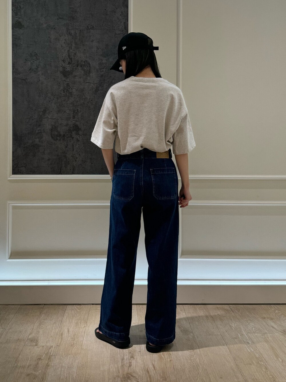 ベージュ系のTシャツ/カットソー、ブルー系のデニムパンツ、ブラック系のサンダルを着用したレディースの春コーディネートの2枚目の写真