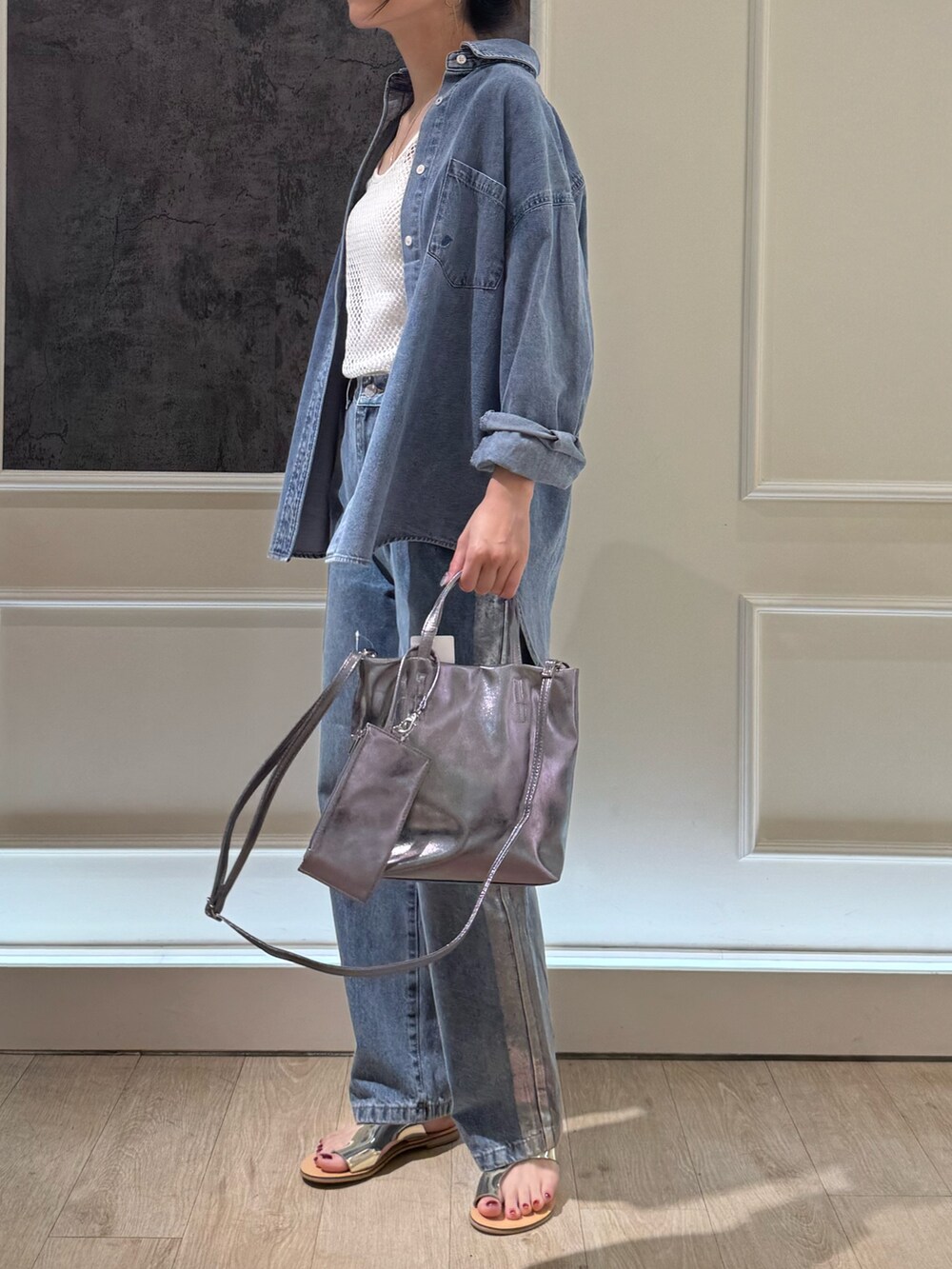 ブルー系のシャツ/ブラウス、シルバー系のショルダーバッグ、ブルー系のデニムパンツを着用したレディースの夏コーディネートの2枚目の写真