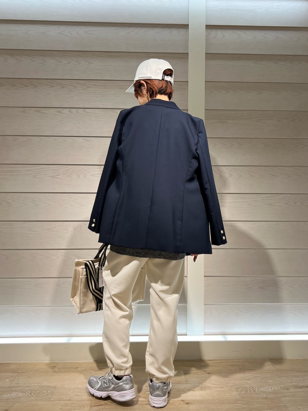 ブルー系のテーラードジャケット、ホワイト系のトートバッグ、ブラック系のその他パンツを着用したレディースの春コーディネートの2枚目の写真