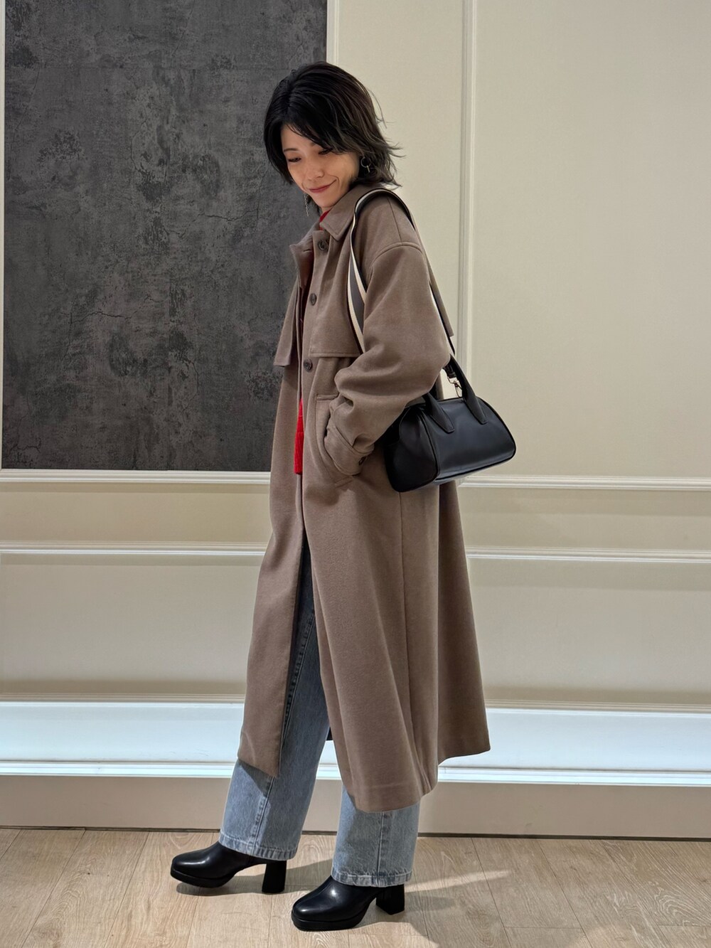 ブルー系のデニムパンツ、ブラック系のブーツ、ブラウン系のステンカラーコートを着用したレディースの冬コーディネートの2枚目の写真