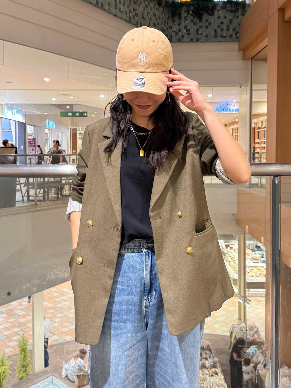 ブラウン系のテーラードジャケット、ブルー系のデニムパンツを着用したレディースの秋コーディネートの2枚目の写真