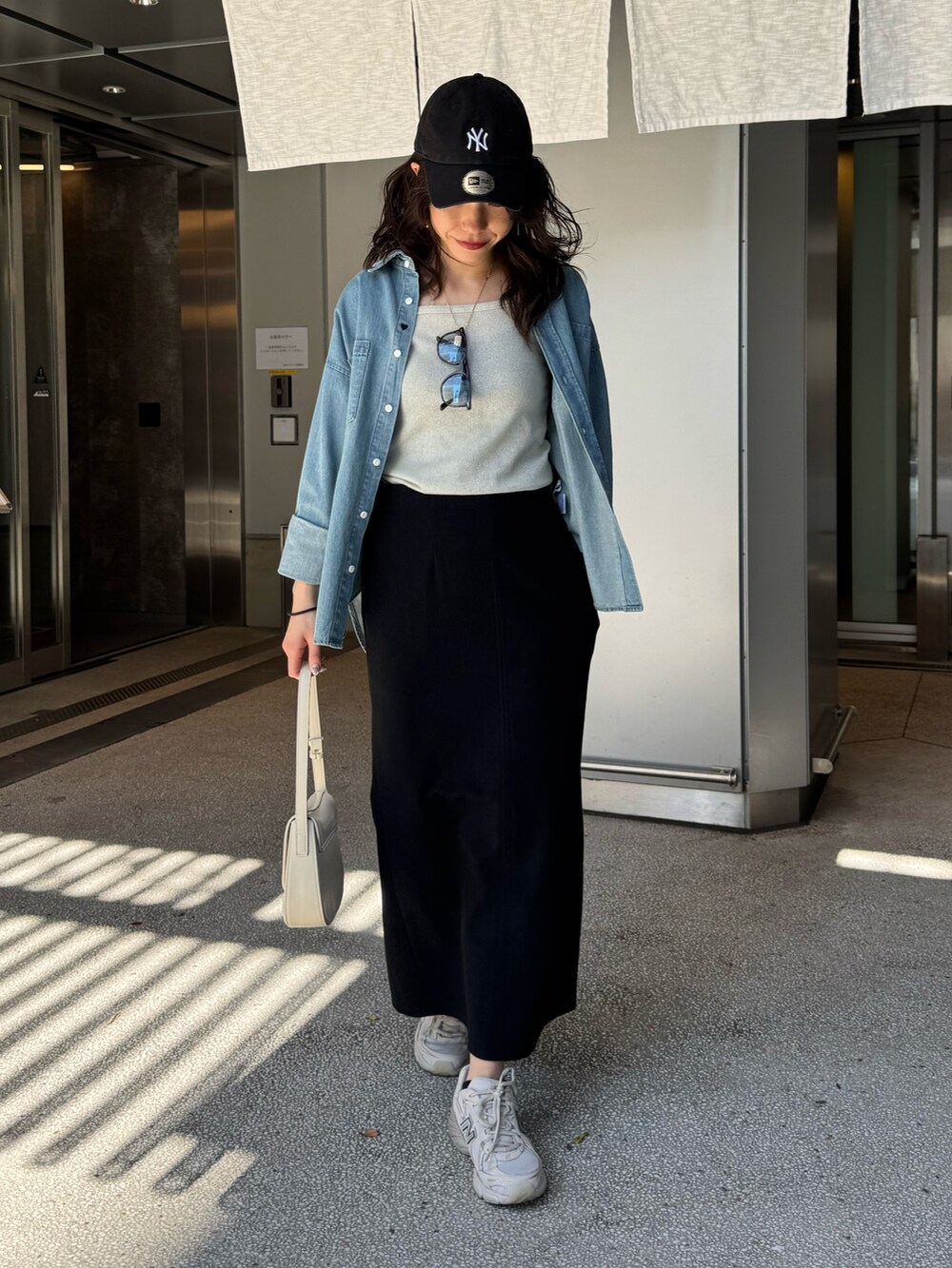 ブルー系のシャツ/ブラウス、ブルー系のスカート、ブラック系のショルダーバッグを着用したレディースの春コーディネートの4枚目の写真