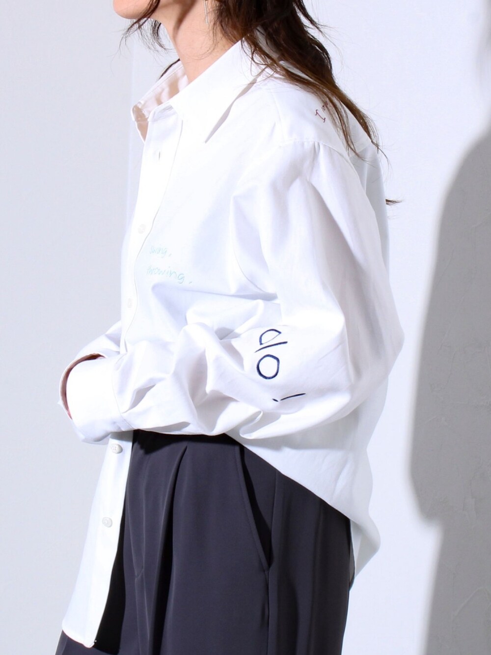 ホワイト系のシャツ/ブラウス、ブラック系のスラックスを着用したレディースの春コーディネートの3枚目の写真