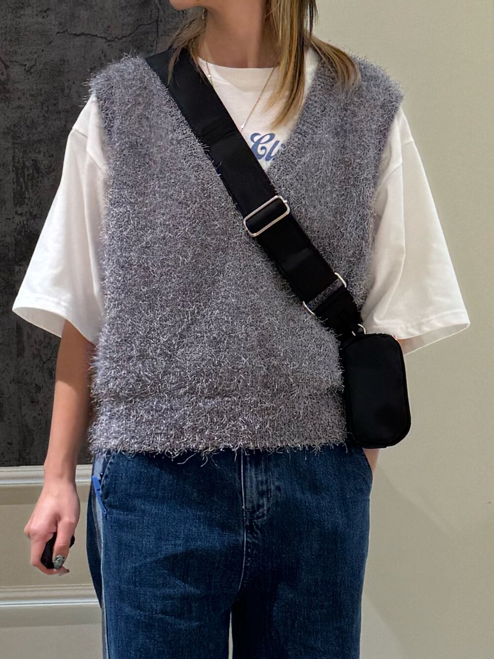 ブルー系のデニムパンツ、グレー系のベスト、ブラック系のショルダーバッグを着用したレディースの夏コーディネートの5枚目の写真