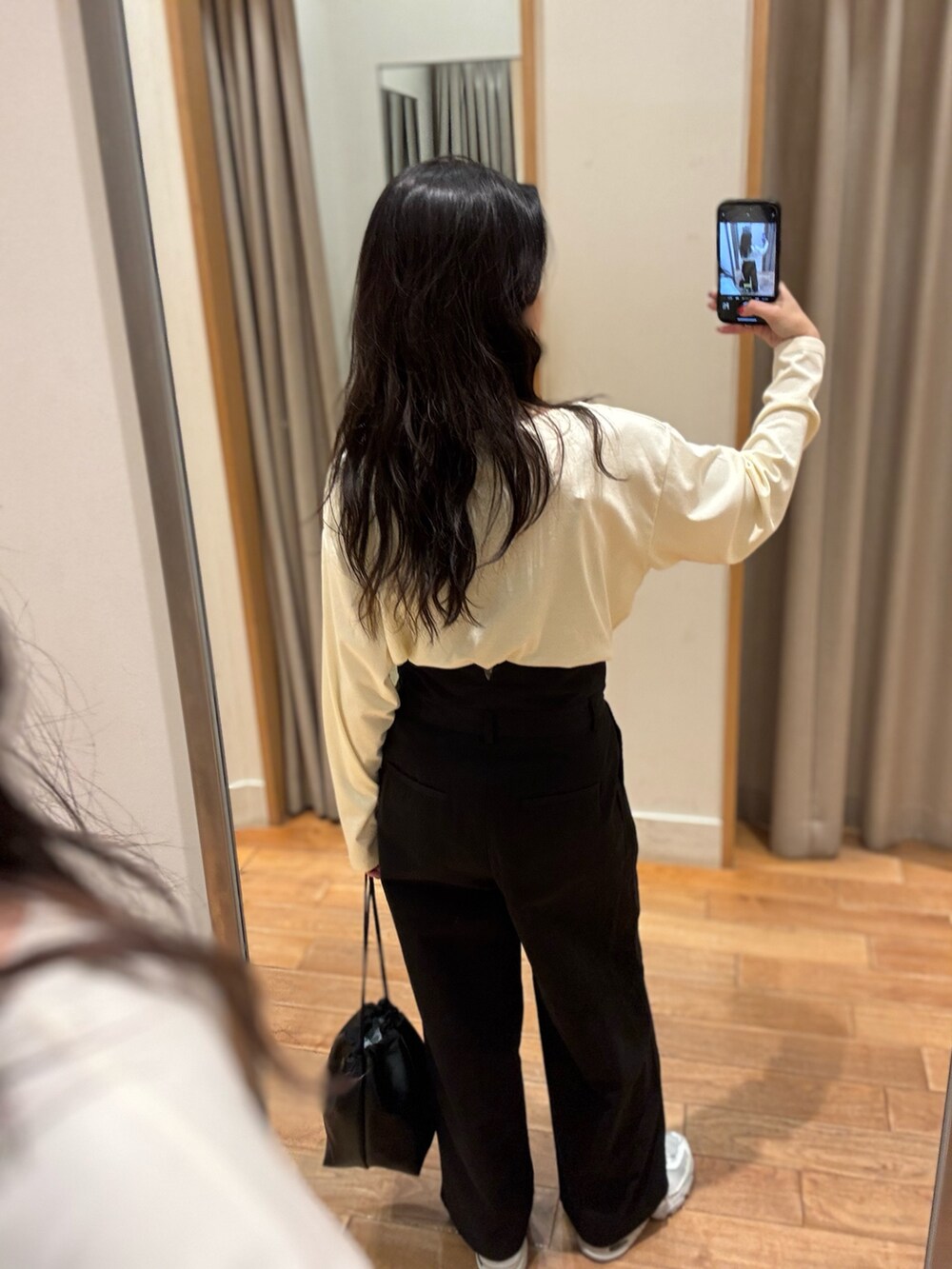 ホワイト系のTシャツ/カットソー、ブラック系のチノパンツを着用したレディースの秋コーディネートの4枚目の写真