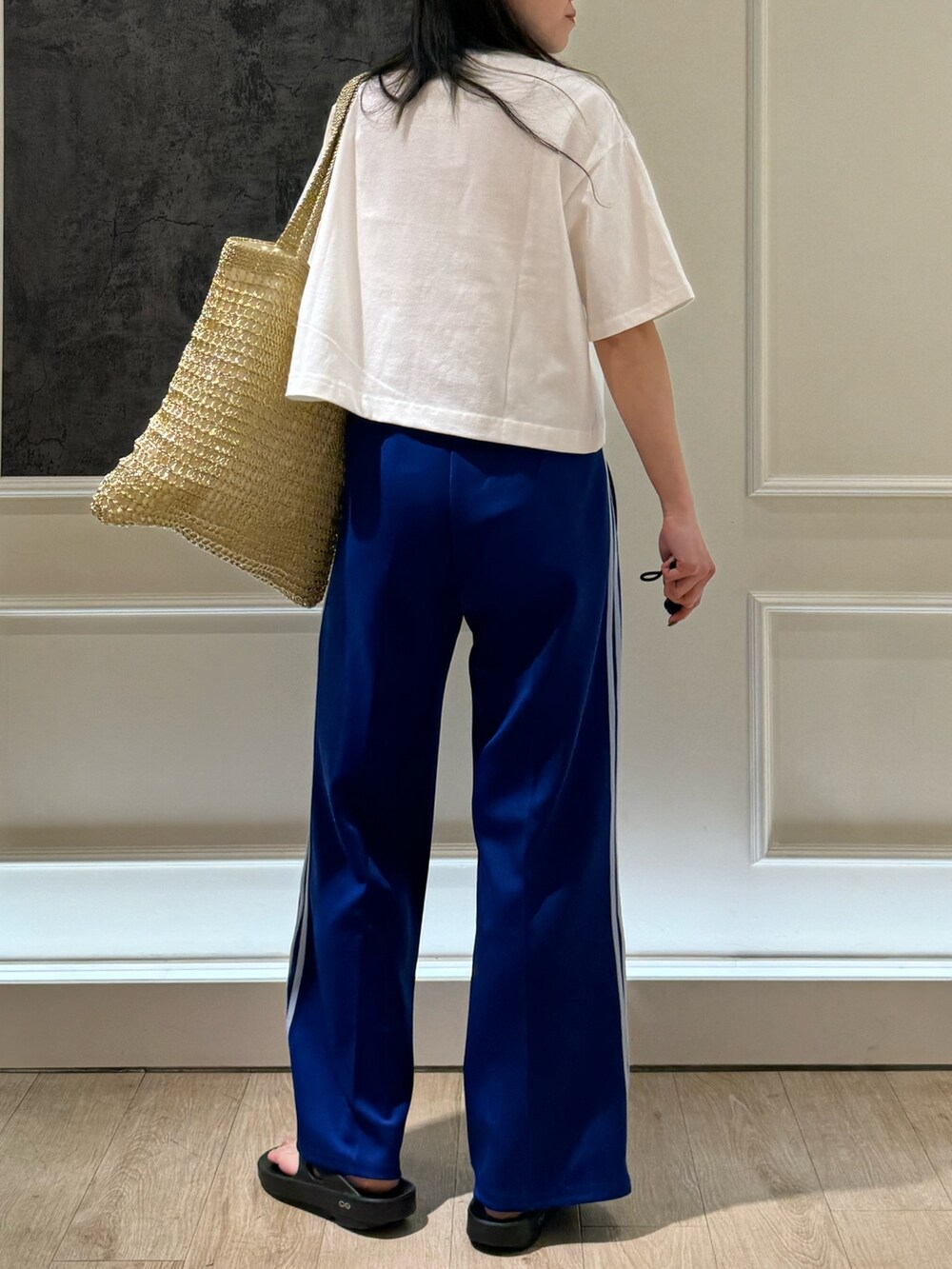 ホワイト系のTシャツ/カットソー、ホワイト系のその他パンツ、ゴールド系のトートバッグを着用したレディースの春コーディネートの4枚目の写真