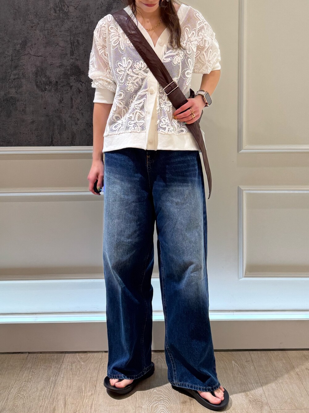 ブラック系のカーディガン/ボレロ、ブルー系のデニムパンツ、ブラウン系のショルダーバッグを着用したレディースの春コーディネートの3枚目の写真