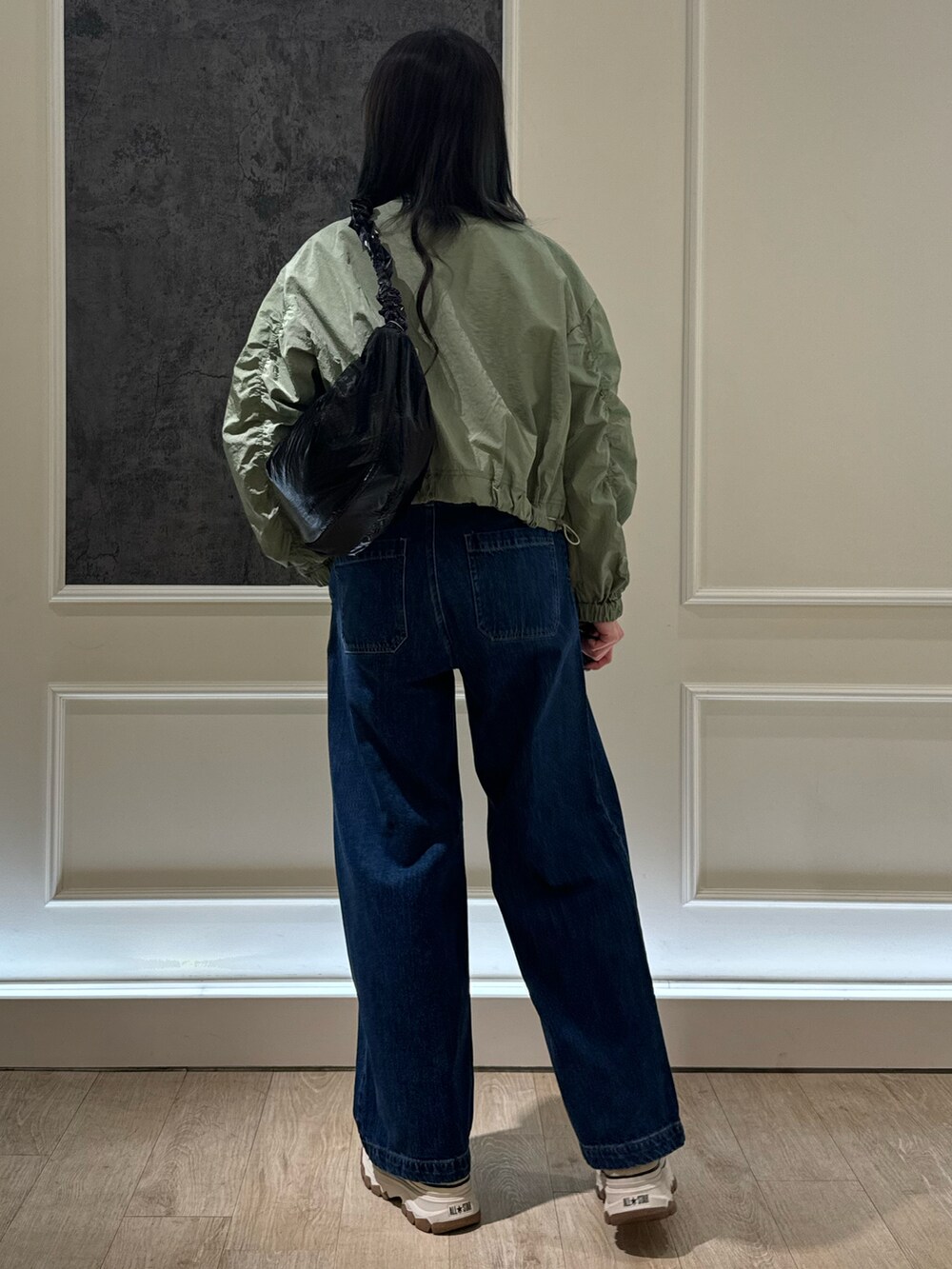 グリーン系のブルゾン、ブルー系のデニムパンツ、ホワイト系のTシャツ/カットソーを着用したレディースの春コーディネートの2枚目の写真