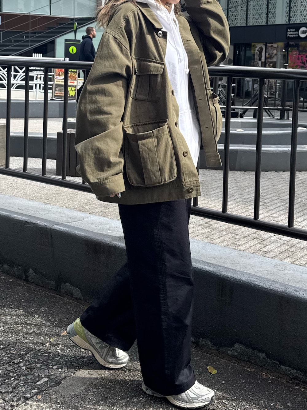 グリーン系のブルゾン、ホワイト系のパーカー、ベージュ系のチノパンツを着用したレディースの春コーディネートの4枚目の写真