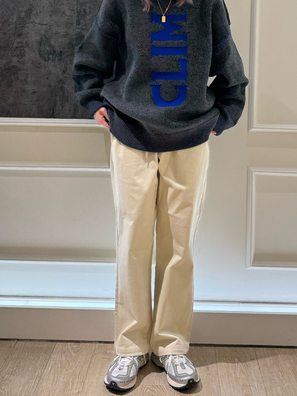 グレー系のニット/セーター、ホワイト系のその他パンツ、ブルー系のキャップを着用したレディースの秋コーディネートの3枚目の写真