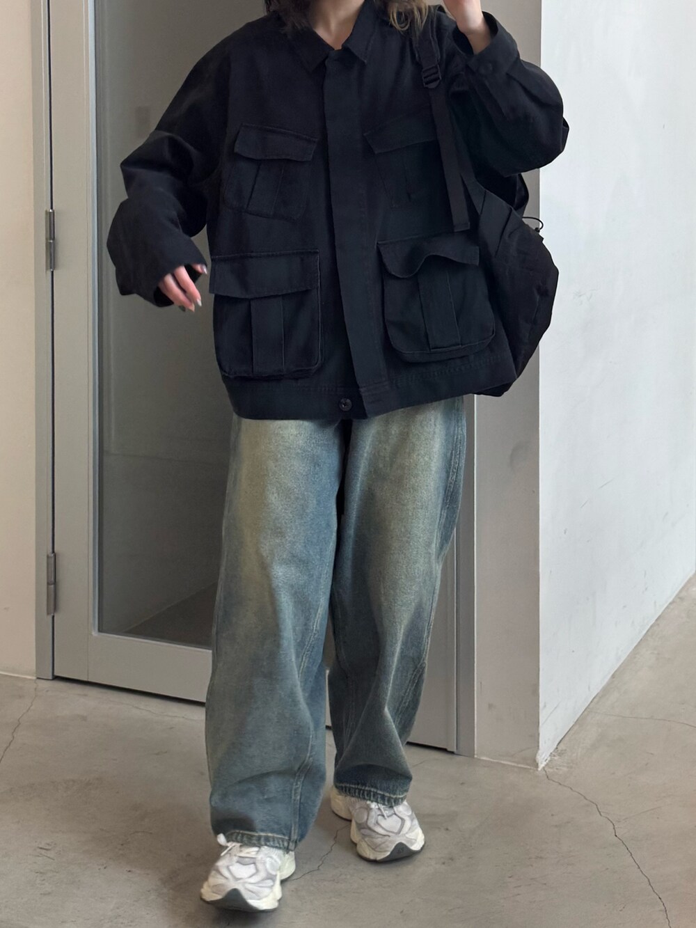 ブラック系のブルゾン、ブルー系のデニムパンツ、ブラック系のバックパック/リュックを着用したレディースの冬コーディネートの2枚目の写真