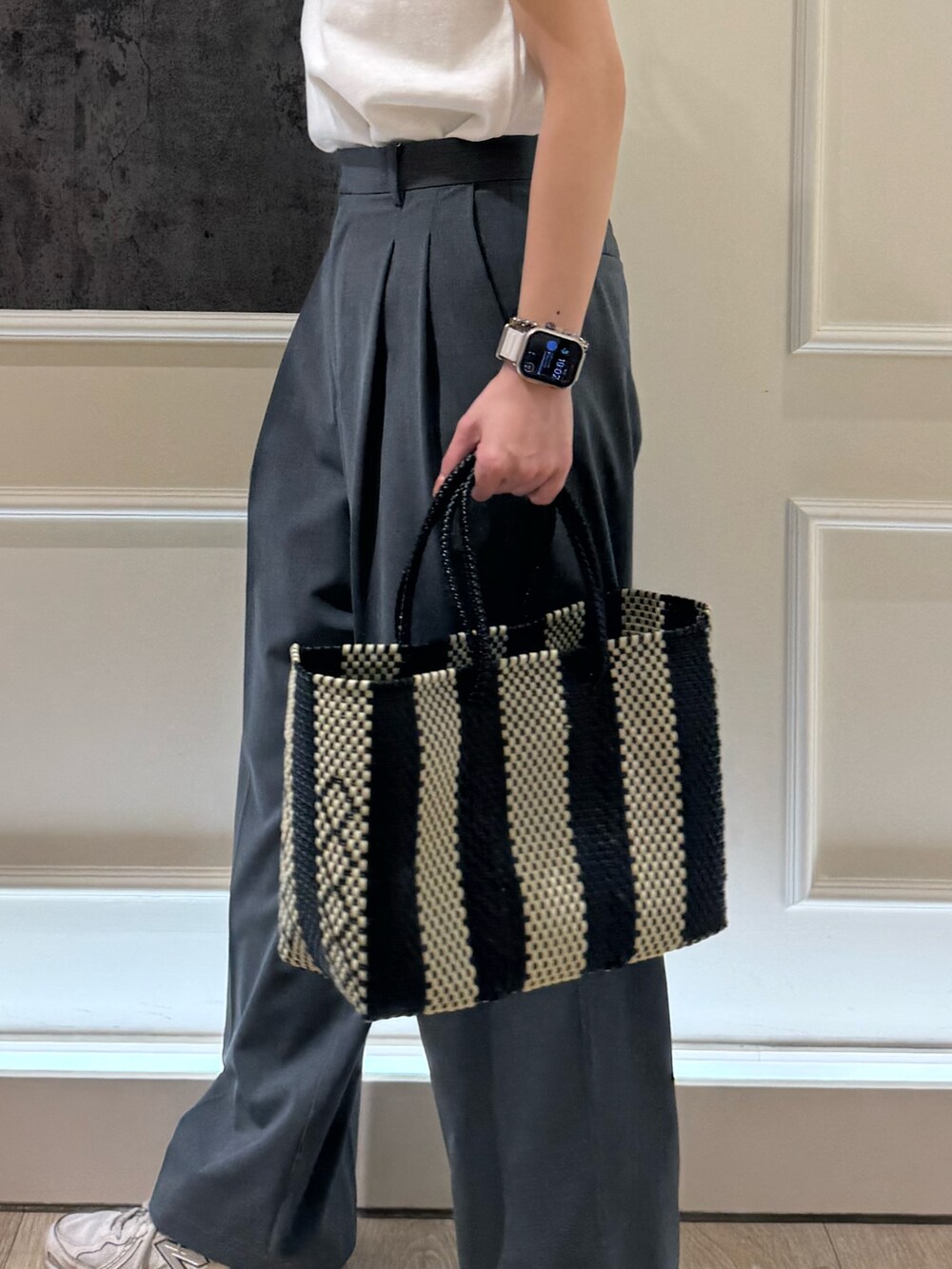 ホワイト系のTシャツ/カットソー、グレー系のスラックス、ブラック系のトートバッグを着用したレディースの夏コーディネートの4枚目の写真